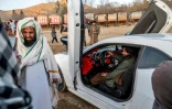 Des talibans font des photos avec une voiture de sport lors d'une compétition automobile dans les anvirons de Kaboul, le 11 février 2024 en Afghanistan
