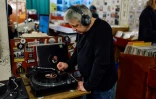 Un client écoute un vinyle de la boutique Flashback Records, le 18 avril 2024 à Londres