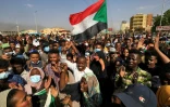 Des manifestants soudanais brandissent des drapeaux lors d'une manifestation à Khartoum pour dénoncer les arrestations par l'armée de membres du gouvernement, le 25 octobre 2021