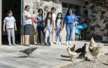 Atanacia Carvete apprend à ses petites-filles nées et vivant aux Etats-Unis (de gauche à droite) Eleny, Briana, Jocelyn, Dianna, Jasmin et Vanessa, à nourrir les poules, à Teopantlan, dans l'Etat mexicain de Puebla, le 19 juillet 2018