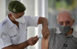 Un militaire vaccine un homme âgé contre le Covid-19 à Belo Horizonte, le 1er mai 2021 au Brésil