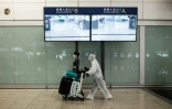 Un passager avec une combinaison de protection, à l'aéroport de Hong Kong, le 19 mars 2020