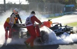 Le pilote de Formule Un Max Verstappen (g) à côté de sa monoplace en feu après son abandon au Grand Prix d'Australie, le 10 avril 2022 à Melbourne