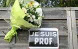 Des fleurs et une affiche "Je suis prof" près du collège du Bois d'Aulne à Conflans-Sainte-Honorine, dans les Yvelines, le 16 octobre 2023