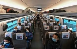 Des voyageurs portant un masque de protection contre le coronavirus dans un train à destination de Wuhan, le 28 mars 2020