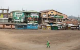 Un employé municipal désinfecte le périmètre d'un marché à Accra, en mars 2020, au Ghana