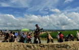 Un garde-frontières bangladais marche près des réfugiés rohingyas, près d'Ukhia, le 17 octobre 2017 au Bangladesh