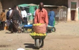 Un vendeur de fruits transporte des oranges, le 17 janvier 2025 à Khartoum au Soudan
