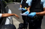 Des gendarmes vérifient les attestations individuelles d'une automobiliste à l'Ile de la Réunion le 19 mars 2020 