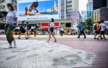 Des habitants de Hong Kong foulent le 2 juin 2020 un trottoir dont les pavés ont été remplacés par du béton par les autorités locales, en réponse aux manifestations pro-démocratie.