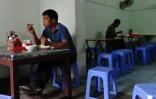 Deux ouvriers venus de la campagne prennent leur déjeuner à Hanoï le 21 septembre 2015 dans un restaurant tenu par d'autres migrants économiques Le Van Mung et Ngoc Anh