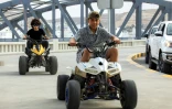 Des enfants sur des quads le long du trottoir piétonnier d'une route surplombant le front de mer de la ville de Derna, dans l'est de la Libye, le 15 mai 2026, après les efforts de reconstruction qui ont suivi tempête Daniel