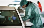Une soignante en combinaison de protection teste un automobiliste, le 28 mars 2020 à Burgos en Espagne