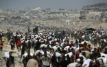 Des Palestiniens transportent des sacs de farine, près de Jabaliya, dans le nord de la bande de Gaza, le 27 juillet 2025