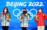 Les patineuses russes Alexandra Trusova (g), médaille d'argent, Anna Shcherbakov (c), médaille d'or, et japonaise Kaori Sakamoto (d), médaille de bronze, le 18 février 2022 aux Jeux olympiques de Pékin