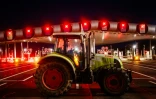 Des agriculteurs bloquent l'autoroute A10 avec des tracteurs, près des barrières de péage du Péage de Saint-Arnoult-en-Yvelines au sud-ouest de Paris, le 26 janvier 2024