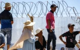 Des personnes attendent derrière une clôture surmontée de barbelés le retour de proches ayant tenté de franchir la frontière pour entrer dans l’enclave espagnole de Ceuta, le 2 août 2026 à Fnideq