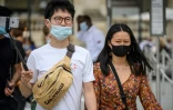 Des touristes asiatiques portent un masque de protection, le 15 août 2020 à Paris
