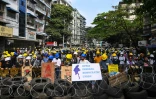 Des manifestants derrière une barricade faite de pneus et de barbelés, le 3 mars 2021 à Rangoun, en Birmanie