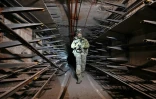Un soldat russe inspecte un tunnel sous l'aciérie Azovstal de Marioupol, prise à l'Ukraine, le 13 juin 2022