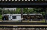 Un homme parle au téléphone à côté d’un train qui a déraillé et s’est renversé à Yatsushiro, dans la préfecture de Kumamoto, le 29 juillet 2026, après qu’un tremblement de terre a frappé le sud-ouest du Japon la veille