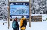 Des personnes regardent la carte du domaine skiable de Villard-de-Lans, le 5 janvier 2021 en Isère