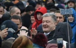 Le président ukrainien Petro Porochenko (C) salue des manifestants réunis devant la cathédrale Sainte-Sophie à Kiev avant un concile historique, le 15 décembre 2018