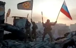 Image tirée d'une vidéo postée sur le compte Telegram de la société Concord, liée à Evguéni Prigojine, montrant des mercenaires du groupe paramilitaire russe Wagner tenant un drapeau russe à Bakhmout, le 20 mai 2023, en Ukraine