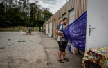 Une femme rom, un enfant dans les bras, devant une maison préfabriquée d'un village d'insertion, le 6 septembre 2018 à Saint-Genis-les-Ollières, près de Lyon