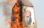 Des Iraniens brûlent une tour en carton, portant une caricature du président américain Donald Trump, à Téhéran, le 10 février 2025