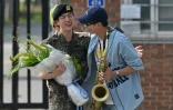 Jin (g), membre du boys band BTS, est salué par RM (d) après avoir été libéré de son service militaire obligatoire à l'extérieur du camp d'entraînement de Yeoncheon, en Corée du Sud, le 12 juin 2024