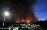 Des personnes regardent les panaches de fumée d'un incendie à Sausset-les-Pins, près de Marseille, le 4 août 2020