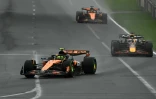 Le pilote britannique de McLaren Lando Norris (g.) mène la course devant le pilote néerlandais de Red Bull Racing Max Verstappen (d.) et le pilote australien de McLaren Oscar Piastri lors du Grand Prix d'Australie de Formule 1, sur le circuit d'Albert Park à Melbourne, le 16 mars 2025
