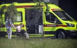 Un ambulancier accompagne un patient en fauteuil roulant vers un hôpital où sont soignées les personnes atteintes du Covid-19, le 17 juin 2021 près de Moscou