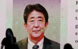 Des passants devant une image de Shinzo Abe sur grand écran dans un quartier de Tokyo le 8 juillet 2022