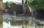 Des habitants dans une zone inondée près de Sukkur, dans la province du Sind, au Pakistan