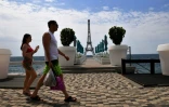 Un couple passe devant une copie de la Tour Eiffel sur une plade la Mer Noire à Yalta, principale station balnéaire sur la péninsule de la Crimée annexée, le 19 juin 2023