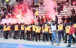 Les stadiers et la police se déploient devant une tribune de supporters équipés de fumigènes durant le match Paris FC-Lyon à Charléty, le 17 décembre 2021
