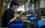 Un employé du fabricant japonais de couteaux Sumikama affûte des lames dans son usine de Seki,au Japon, le 22 juillet 2025