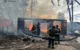 Des pompiers luttent contre un incendie après une frappe russe sur Kherson, le 21 avril 2024 en Ukraine