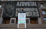 Un homme tient une pancarte "Famine massive dans Olechky occupée. Américains ! Contraignez la Russie à accepter un couloir humanitaire" devant l'hôtel de ville de Kiev, en Ukraine, le 20 septembre 2026