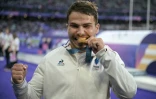 Le Français Antoine Dupont célèbre sa médaille d'or lors de la cérémonie qui suit le match de rugby à VII entre la France et les Fidji, lors des Jeux olympiques de Paris 2024 au Stade de France à Saint-Denis, le 27 juillet 2024