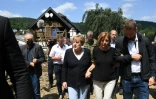 La chancelière allemande Angela Merkel (c) dans le village de Schuld, ravagé par 
les inondations, près de Bad Neuenahr-Ahrweiler, le 18 juillet 2021 en Allemagne