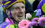 Le cycliste centenaire amateur français Robert Marchand, 106 ans, reçoit un bouquet de fleurs après avoir achevé un 4.000 mètres au vélodrome de Saint-Quentin-en-Yvelines, le 11 février 2018