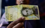 Un homme tient un billet de 100.000 bolivar à Caracas le 9 novembre 2017