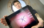 Le créateur du jeu vidéo Plague Inc., James Vaughan, avec une tablette qui montre une image du jeu, le 7 novembre 2014 à Londres