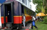 Des jeunes femmes montent dans un wagon de train reconverti en café, le 5 juin 2021 à Phnom Penh, au Cambodge
