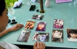 Odile Dussart, évacuée de Saïgon alors qu'elle n'était qu'un bébé de 11 mois, quelques semaines avant la fin de la guerre du Vietnam il y a 50 ans, montre des photos de famille dans sa nouvelle maison à Hoi An, le 12 avril 2025
