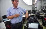 Le professeur Viboon Sangveraphunsiri montre un robot modifié pour s'occuper de malades atteints du coronavirus, le 18 mars 2020 à l'Université de Chulalongkorn à Bangkok