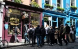 Des touristes devant une boutique de produits dérivés, rue Victoria, après avoir suivi le "Potter trail", le 5 juin 2024 à Edimbourg, en Ecosse